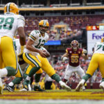 
              Green Bay Packers quarterback Aaron Rodgers (12) prepares to hand the ball off to running back AJ Dillon (28)during the first half of an NFL football game against the Washington Commanders, Sunday, Oct. 23, 2022, in Landover, Md. (AP Photo/Patrick Semansky)
            