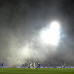 
              Players of Gimnasia de La Plata and Boca Juniors run after the ball as tear gas invades the field in La Plata, Argentina, Thursday, Oct. 6, 2022. The match was suspended after tear gas thrown by the police outside the stadium wafted inside affecting the players as well as fans who fled to the field to avoid its effects. (AP Photo/Gustavo Garello)
            