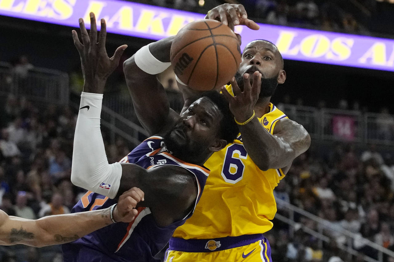 Phoenix Suns center Deandre Ayton (22) and Los Angeles Lakers forward LeBron James (6) battle for t...