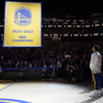 
              Golden State Warriors guard Stephen Curry, right, watches as the 2021-2022 NBA Championship banner is raised before the team's basketball game against the Los Angeles Lakers in San Francisco, Tuesday, Oct. 18, 2022. (AP Photo/Godofredo A. Vásquez)
            