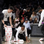 
              Attendants clean the court after a spectator threw a beverage from the stands during overtime of an NBA basketball game between the Brooklyn Nets and the Dallas Mavericks, Thursday, Oct. 27, 2022, in New York. (AP Photo/John Minchillo)
            
