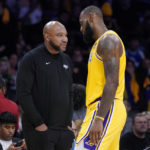 
              Los Angeles Lakers forward LeBron James, right, walks back to the bench as head coach Darvin Ham stands on the court during the second half of an NBA basketball game against the Los Angeles Clippers Thursday, Oct. 20, 2022, in Los Angeles. (AP Photo/Mark J. Terrill)
            