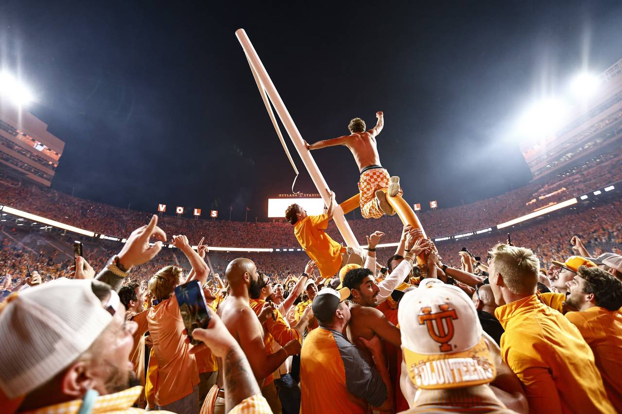 Tennessee fans tear down the goal post after defeating Alabama 52-49 in an NCAA college football ga...