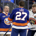 
              Former New York Islanders' Ed Westfall talks with Anders Lee (27) after dropping a ceremonial first puck before the team's NHL hockey game against the Florida Panthers on Thursday, Oct. 13, 2022, in Elmont, N.Y.  Panthers center Aleksander Barkov is at right. (AP Photo/Adam Hunger)
            