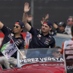 
              Red Bull driver Sergio Perez, of Mexico, left, and teammate Max Verstappen, of the Netherlands, wave to the crowd during the parade prior to the Formula One Mexico Grand Prix auto race at the Hermanos Rodriguez racetrack in Mexico City, Sunday, Oct. 30, 2022. (AP Photo/Fernando Llano)
            