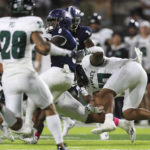 
              Nevada running back Cross Patton (0) gets wrapped up by the Hawaii defense during the first half of an NCAA college football game on Saturday, Oct. 15, 2022, in Honolulu. (AP Photo/Marco Garcia)
            