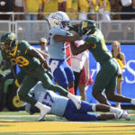 
              Baylor running back Richard Reese scores a touchdown over Kansas defensive end Lonnie Phelps in the first half of an NCAA college football game, Saturday, Oct. 22, 2022, in Waco, Texas. (AP Photo/Jerry Larson)
            