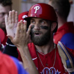 
              Philadelphia Phillies' Bryce Harper celebrates in the dugout after scoring on a single by Alec Bohm during the second inning in Game 2 of the baseball NL Championship Series between the San Diego Padres and the Philadelphia Phillies on Wednesday, Oct. 19, 2022, in San Diego. (AP Photo/Gregory Bull)
            