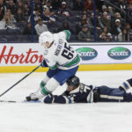 
              Columbus Blue Jackets' Nick Blankenburg, bottom, trips Vancouver Canucks' Ilya Mikheyev during the third period of an NHL hockey game Tuesday, Oct. 18, 2022, in Columbus, Ohio. Blankenburg was penalized for the play. (AP Photo/Jay LaPrete)
            
