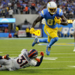 
              Los Angeles Chargers wide receiver Mike Williams (81) breaks the tackle of Denver Broncos safety Justin Simmons (31) during the first half of an NFL football game, Monday, Oct. 17, 2022, in Inglewood, Calif. (AP Photo/Mark J. Terrill)
            