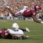 
              Oklahoma defensive back Trey Morrison (6) flies over as teammate Woodi Washington (0) tackles Texas wide receiver Xavier Worthy during the first half of an NCAA college football game at the Cotton Bowl in Dallas, Saturday, Oct. 8, 2022. (AP Photo/LM Otero)
            