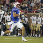
              SMU quarterback Tanner Mordecai (8) rushes for a touchdown against Navy defender Elias Larry (3) during the third quarter of an NCAA college football game in Dallas, Friday, Oct. 14, 2022. (AP Photo/LM Otero)
            