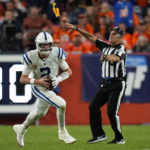 
              The referee throws a flag as Indianapolis Colts quarterback Matt Ryan (2) runs during the first half of an NFL football game against the Denver Broncos, Thursday, Oct. 6, 2022, in Denver. (AP Photo/Jack Dempsey)
            