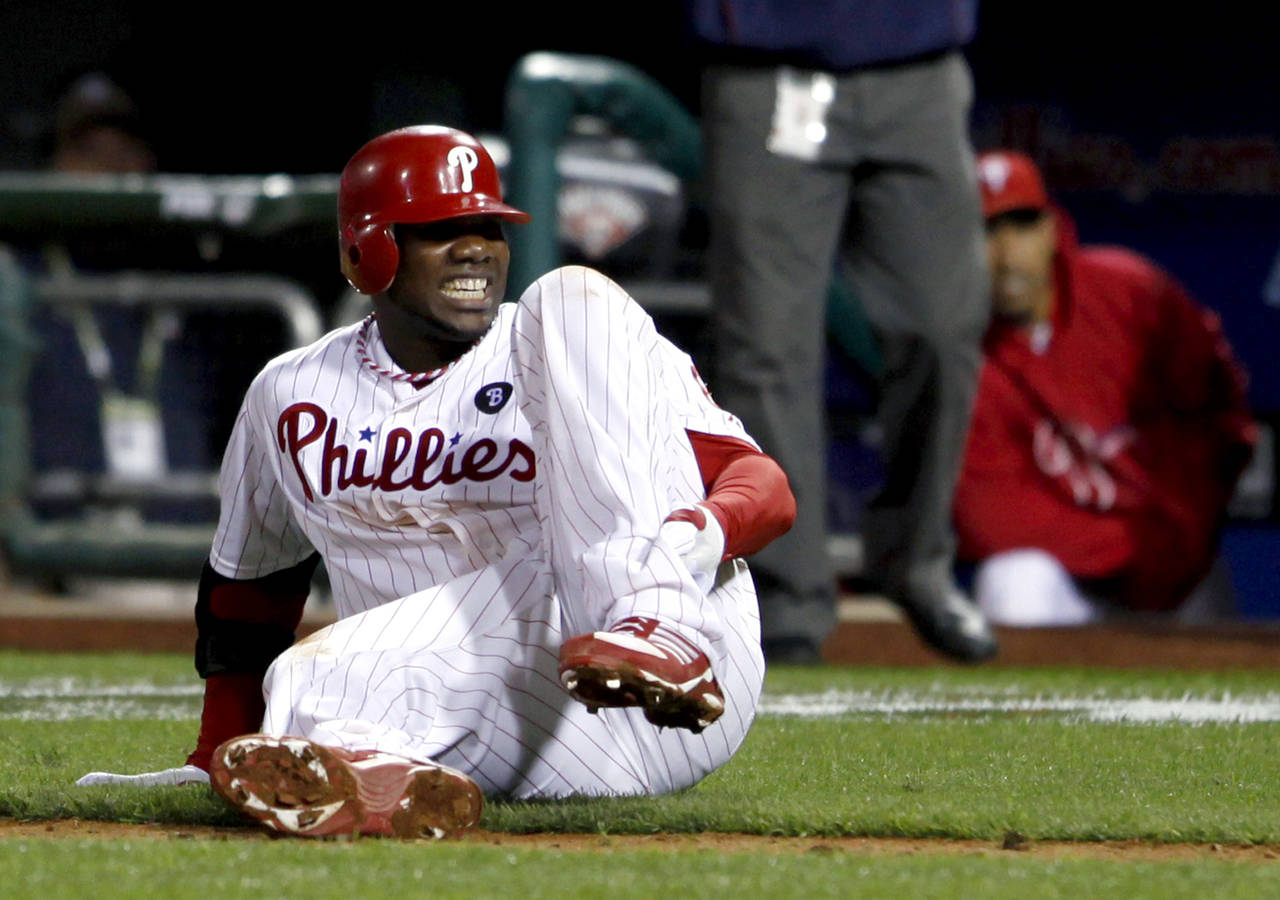 FILE - Philadelphia Phillies' Ryan Howard reacts after falling down injured on his way to first bas...