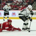 
              Detroit Red Wings center Dylan Larkin (71) pokes the puck from Los Angeles Kings left wing Viktor Arvidsson (33) on an empty net break away in the third period of an NHL hockey game Monday, Oct. 17, 2022, in Detroit. (AP Photo/Paul Sancya)
            