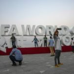 
              FILE - People take photographs in front of a sign representing FIFA World Cup 2022, on Doha's corniche, only 30 days away from the event in Qatar on Oct. 21, 2022. The FIFA World Cup may be bringing as many as 1.2 million fans to Qatar, but the nearby flashy emirate of Dubai is also looking to cash in on the major sports tournament taking place just a short flight away. (AP Photo/Nariman El-Mofty, File)
            