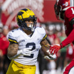 
              Michigan running back Blake Corum (2) runs the ball into the Indiana defense during the first half of an NCAA college football game, Saturday, Oct. 8, 2022, in Bloomington, Ind. (AP Photo/Doug McSchooler)
            