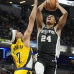 
              San Antonio Spurs guard Devin Vassell (24) shoots over Indiana Pacers guard Andrew Nembhard (2) during the first half of an NBA basketball game in Indianapolis, Friday, Oct. 21, 2022. (AP Photo/AJ Mast)
            