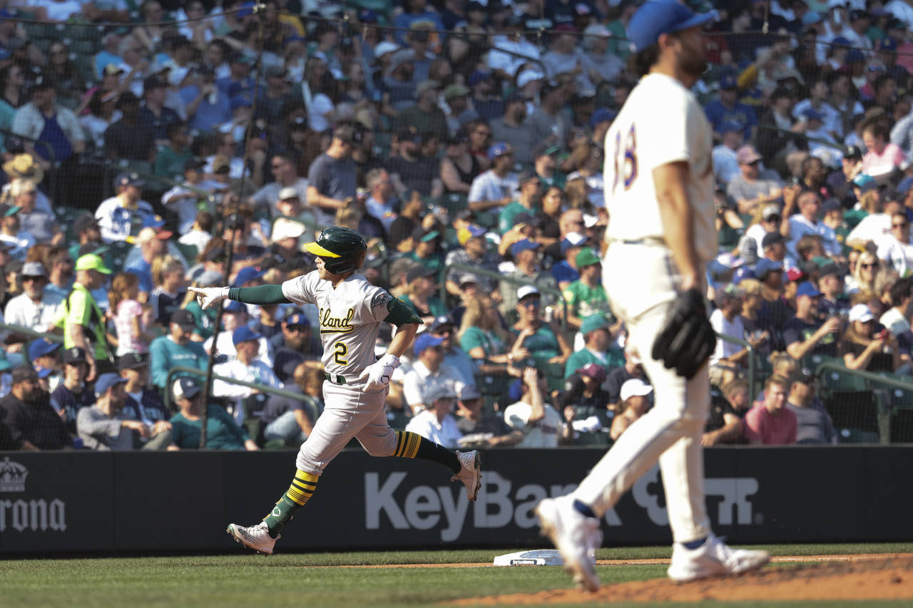 Oakland Athletics' Nick Allen, left, rounds third after hitting a two-run home run as Seattle Marin...