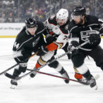 
              Anaheim Ducks defenseman Josh Mahura, center, is squeezed between Los Angeles Kings defenseman Mikey Anderson, left, and defenseman Drew Doughty during the first period of a preseason NHL hockey game Sunday, Oct. 2, 2022, in Los Angeles. (AP Photo/Mark J. Terrill)
            