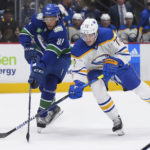 
              Vancouver Canucks' Dakota Joshua, left, and Buffalo Sabres' Tage Thompson vie for the puck during the first period of an NHL hockey game Saturday, Oct. 22, 2022, in Vancouver, British Columbia. (Darryl Dyck/The Canadian Press via AP)
            