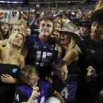 
              Fans try to get a photo with TCU quarterback Max Duggan (15) after the team's win over Kansas State in an NCAA college football game Saturday, Oct. 22, 2022, in Fort Worth, Texas. (AP Photo/Richard W. Rodriguez)
            