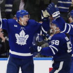 
              Toronto Maple Leafs' Justin Holl (3) celebrates his goal against the Ottawa Senators with tMichael Bunting and Auston Matthews during the third period of an NHL hockey game Saturday, Oct. 15, 2022, in Toronto. (Frank Gunn/The Canadian Press via AP)
            