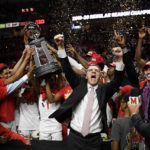 
              FILE - Maryland head coach Mark Turgeon, center right, and his team celebrate after they won a share of the Big Ten regular season title after defeating Michigan in an NCAA college basketball game, Sunday, March 8, 2020, in College Park, Md. In basketball, whether a team wins a  conference regular-season title, a conference tournament title or no conference title at all has very little bearing on what the final verdict will be. (AP Photo/Nick Wass, File)
            