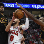 
              Chicago Bulls' Zach LaVine (8) goes up to shoot against Cleveland Cavaliers' Jarrett Allen (31) and Evan Mobley (4) during the second half of an NBA basketball game Saturday, Oct. 22, 2022, in Chicago. (AP Photo/Paul Beaty)
            