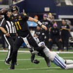 
              Washington Commanders quarterback Carson Wentz (11) throws a pass under pressure from Dallas Cowboys safety Donovan Wilson (6) in the second half of a NFL football game in Arlington, Texas, Sunday, Oct. 2, 2022. Wentz was penalized for intentional grounding on the play. (AP Photo/Ron Jenkins)
            
