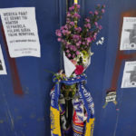 
              Posters and flowers hang on gate 13 of the Kanjuruhan Stadium in Malang, Indonesia, Tuesday, Oct. 4, 2022. Indonesian police said Tuesday that the gates at the soccer stadium where police fired tear gas and set off a deadly crush were too small and could only accommodate two at a time when hundreds were trying to escape.(AP Photo/Achmad Ibrahim)
            