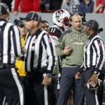 
              North Carolina State head coach Dave Doeren, third from right, talks with an official during a review in the first half of an NCAA college football game against Virginia Tech in Raleigh, N.C., Thursday, Oct. 27, 2022. (AP Photo/Karl B DeBlaker)
            