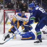 
              Buffalo Sabres' Rasmus Dahlin (26) slides to block a shot by Vancouver Canucks' Ilya Mikheyev (65), in front of Sabres goalie Craig Anderson (41) during the third period of an NHL hockey game Saturday, Oct. 22, 2022, in Vancouver, British Columbia. (Darryl Dyck/The Canadian Press via AP)
            