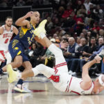
              Chicago Bulls' Alex Caruso tries to control a loose ball as Indiana Pacers' Andrew Nembhard watches during the first half of an NBA basketball game Wednesday, Oct. 26, 2022, in Chicago. (AP Photo/Charles Rex Arbogast)
            