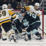 
              Seattle Kraken goalie Martin Jones, center, and defenseman Vince Dunn, second from right, stop a shot by Pittsburgh Penguins forward Jake Guentzel, second from left, during the first period of an NHL hockey game, Saturday, Oct. 29, 2022, in Seattle. The Kraken won 3-1. (AP Photo/Stephen Brashear)
            