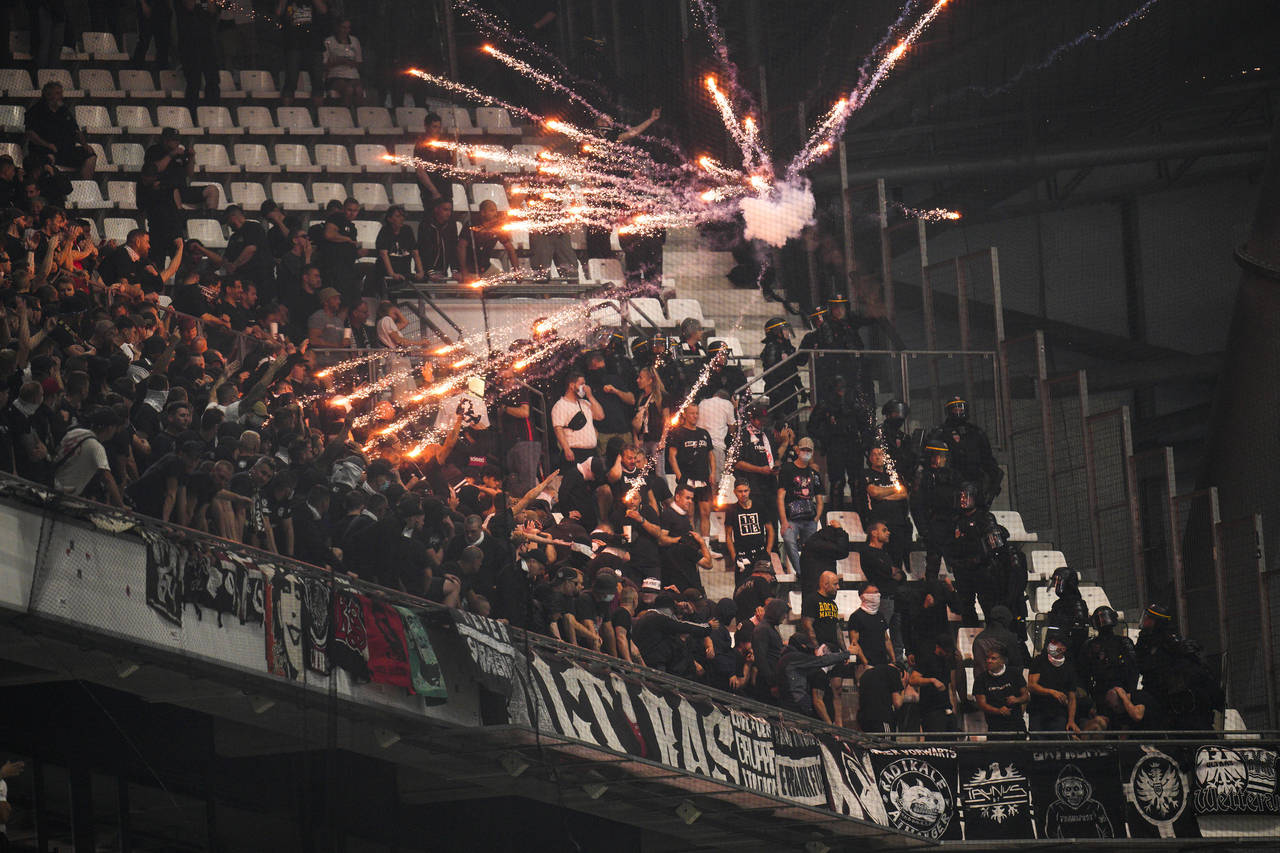 FILE - Fireworks thrown by Marseille supporters explode next to Frankfurt supporters prior to the C...