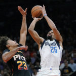 
              Dallas Mavericks guard Spencer Dinwiddie (26) gets a shot off over Phoenix Suns forward Cameron Johnson (23) during the first half of an NBA basketball game in Phoenix, Wednesday, Oct. 19, 2022. (AP Photo/Ross D. Franklin)
            