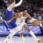 
              Oklahoma City Thunder guard Aaron Wiggins (21) drives the ball against Los Angeles Clippers guard Luke Kennard (5) during the first half of an NBA basketball game Tuesday, Oct. 25, 2022, in Oklahoma City. (AP Photo/Garett Fisbeck)
            