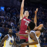 
              Miami Heat guard Duncan Robinson, top, shoots between Golden State Warriors forward JaMychal Green (1), guard Jordan Poole, right, and forward Andrew Wiggins during the first half of an NBA basketball game in San Francisco, Thursday, Oct. 27, 2022. (AP Photo/Jeff Chiu)
            