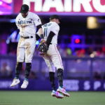 
              Miami Marlins second baseman Jon Berti, left, and shortstop Miguel Rojas (11) celebrate after the Marlins beat the Atlanta Braves 4-0 in a baseball game, Monday, Oct. 3, 2022, in Miami. (AP Photo/Wilfredo Lee)
            