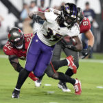 
              Baltimore Ravens running back Gus Edwards (35) runs with the ball as he slips past Tampa Bay Buccaneers safety Keanu Neal (22) during the first half of an NFL football game Thursday, Oct. 27, 2022, in Tampa, Fla. (AP Photo/Chris O'Meara)
            