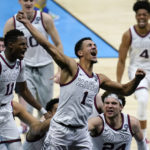 
              FILE - Gonzaga guard Jalen Suggs (1) celebrates making the game winning basket against UCLA during overtime in a men's Final Four NCAA college basketball tournament semifinal game, Saturday, April 3, 2021, at Lucas Oil Stadium in Indianapolis. Gonzaga won 93-90. A few years ago, with the football-playing Mountain West Conference perennially knocking on the door, Gonzaga cut a deal with the WCC: It would stay in the hoops-only league if, instead of splitting things evenly, the conference would give the Zags a bigger share of its NCAA tournament proceeds based on how they performed in March. (AP Photo/Michael Conroy, File)
            