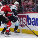 
              Seattle Kraken left wing Andre Burakovsky, right, battles for the puck against Chicago Blackhawks defenseman Jack Johnson during the first period of an NHL hockey game in Chicago, Sunday, Oct. 23, 2022. (AP Photo/Nam Y. Huh)
            