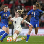 
              England's Lauren Hemp, centre, challenges for the ball with United States' Andi Sullivan, left, and United States' Sofia Huerta, right, during the women's friendly soccer match between England and the US at Wembley stadium in London, Friday, Oct. 7, 2022. (AP Photo/Kirsty Wigglesworth)
            