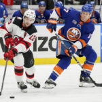 
              New Jersey Devils center Nico Hischier (13) is defended by New York Islanders left wing Matt Martin (17) during the second period of an NHL hockey game Thursday, Oct. 20, 2022, in Elmont, N.Y. (AP Photo/Julia Nikhinson)
            