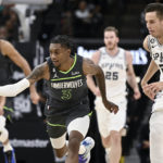 
              Minnesota Timberwolves' Jaden McDaniels (3) and San Antonio Spurs' Zach Collins chase the ball during the first half of an NBA basketball game, Sunday, Oct. 30, 2022, in San Antonio. (AP Photo/Darren Abate)
            