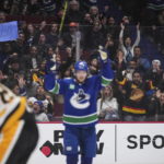 
              Fans behind Vancouver Canucks' Elias Pettersson celebrate Oliver Ekman-Larsson's goal against the Pittsburgh Penguins during the third period of an NHL hockey game in Vancouver, British Columbia on Friday, Oct. 28, 2022. (Darryl Dyck/The Canadian Press via AP)
            