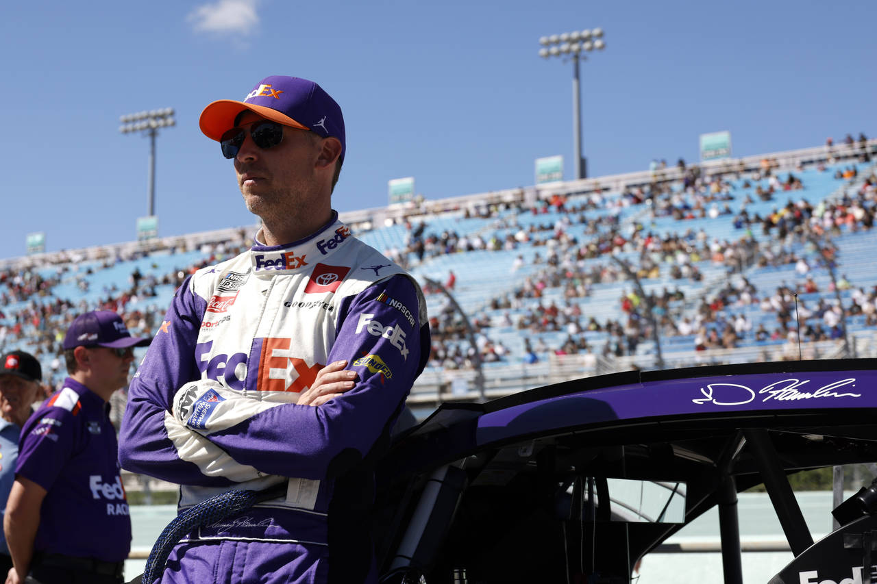 Driver Denny Hamlin leans on his car before a NASCAR Cup Series auto race at Homestead-Miami Speedw...