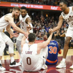 
              Cleveland Cavaliers forward Kevin Love (0) is helped up by forward Dean Wade, left, guard Donovan Mitchell, second from left, and forward Evan Mobley (4) during the second half of an NBA basketball game against the New York Knicks, Sunday, Oct. 30, 2022, in Cleveland. (AP Photo/Nick Cammett)
            