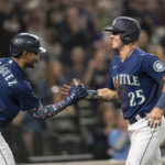 
              Seattle Mariners' Dylan Moore, right, is congratulated by Julio Rodriguez after scoring a run during the fifth inning of a baseball game against the Detroit Tigers, Monday, Oct. 3, 2022, in Seattle. (AP Photo/Stephen Brashear)
            